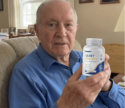 Man in a blue shirt holding a bottle of Quiet Nerves on the sofa